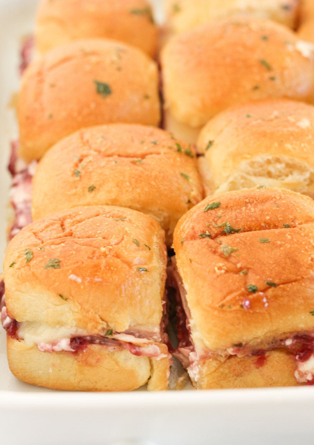 Baked turkey cranberry sliders cut into roll sized sandwiches.