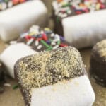 Chocolate dipped marshmallows with toppings on a tray.