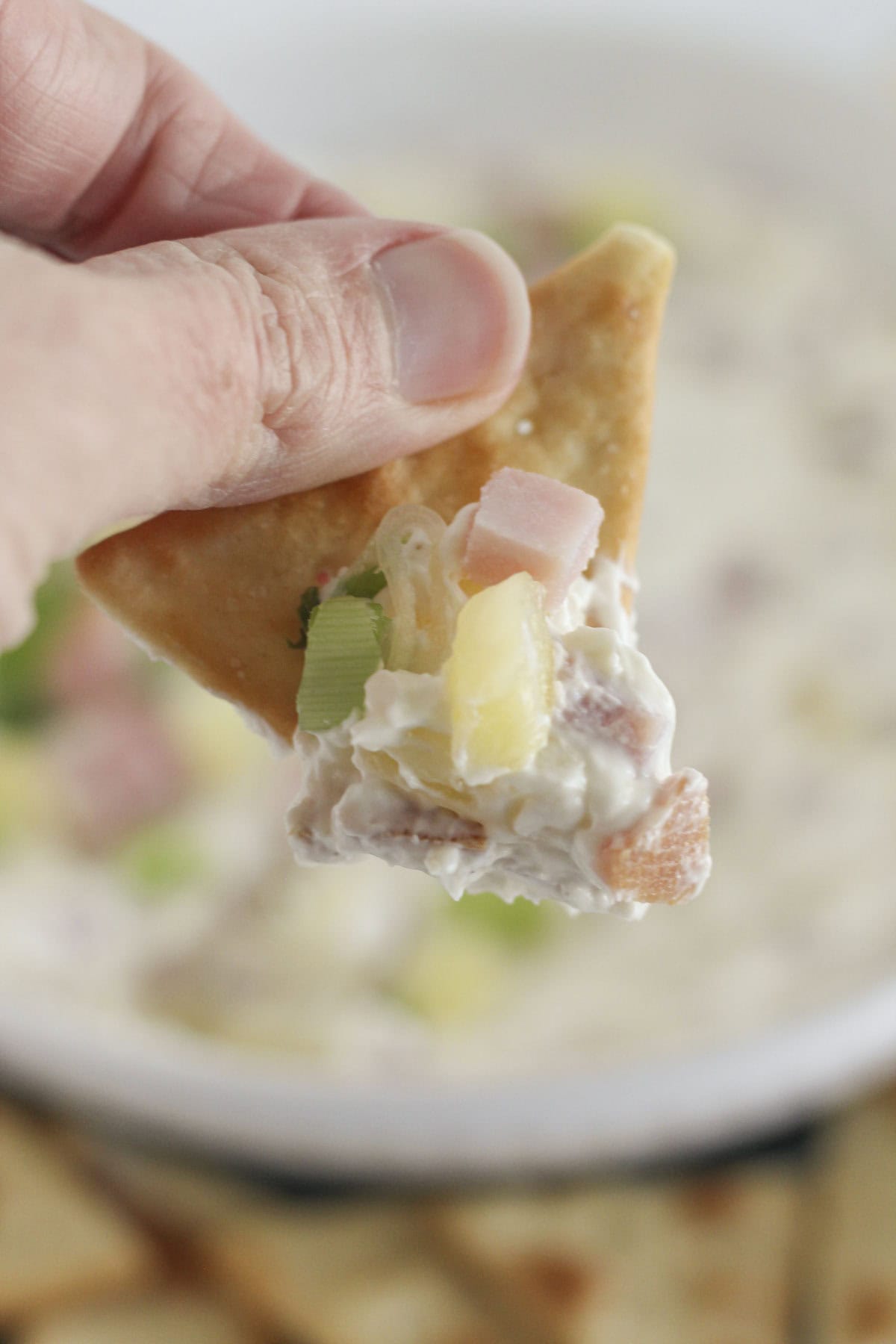 Scooping Hawaiian dip on a pita cracker.