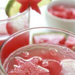 Watermelon limeade is served in glasses with a garnish of lime and watermelon.