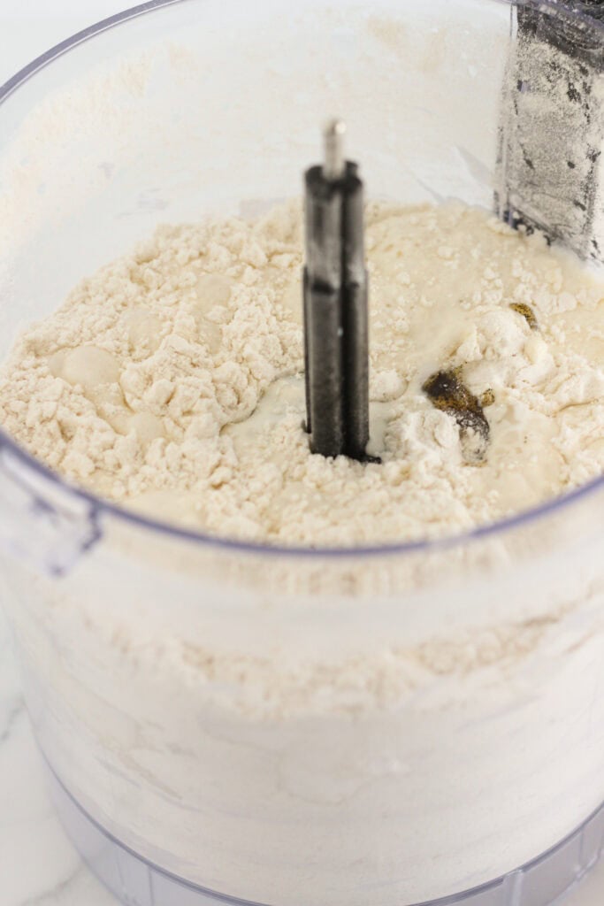 Coarse crumbs in the food processor after pulsing the ingredients.