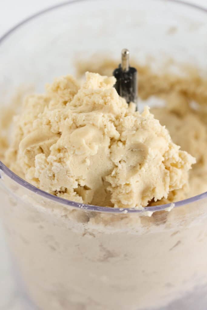Adding wet ingredients and pulsing the food processor until it forms a ball.