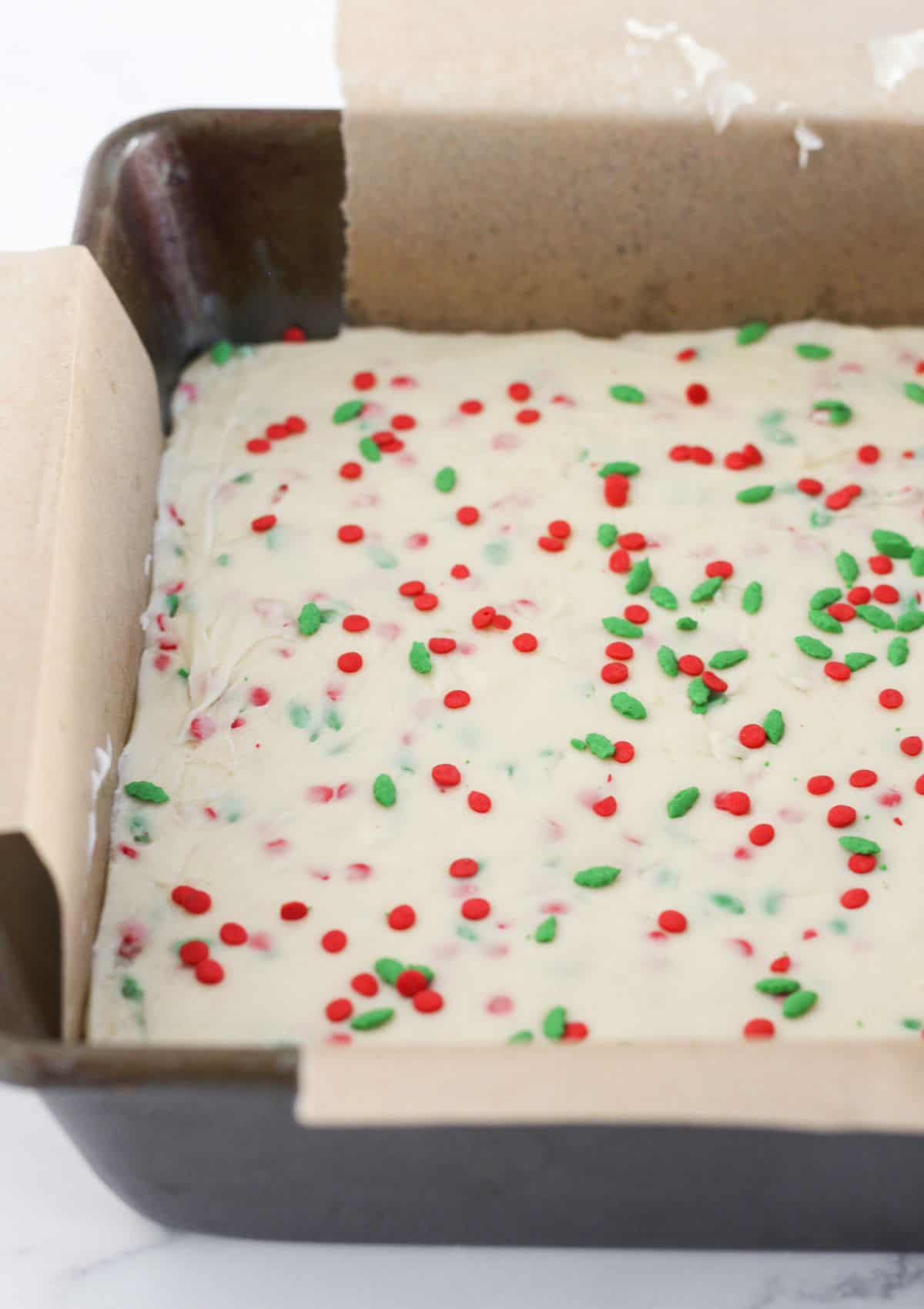 The white chocolate layer on top of the chocolate layer with holiday sprinkles.