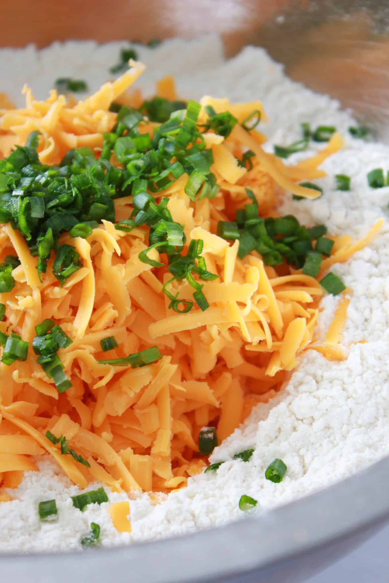 Combining the dry ingredients with the shredded cheddar and chives.