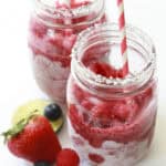 Two frozen fruit daiquiris in mason jars with straws.
