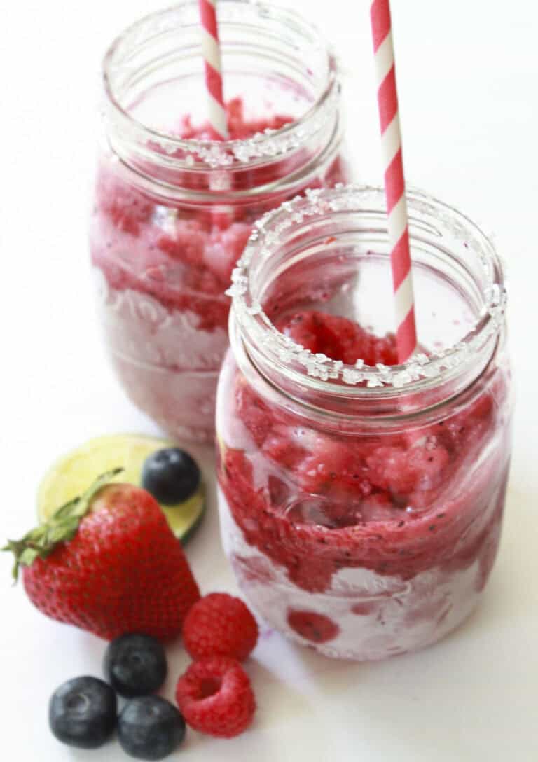 Two frozen fruit daiquiris in mason jars with straws.