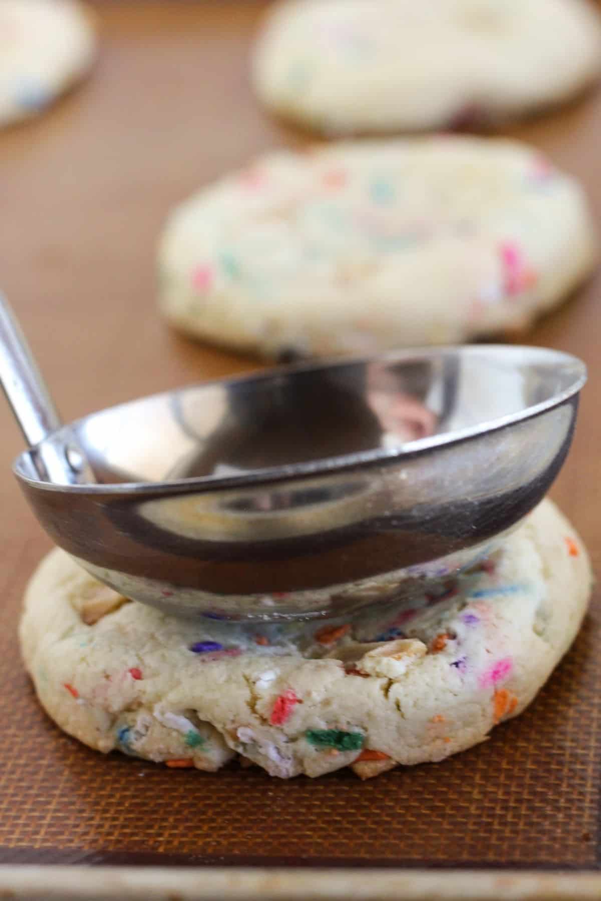 Making an indention for the ice cream in top of cookies with ladel.