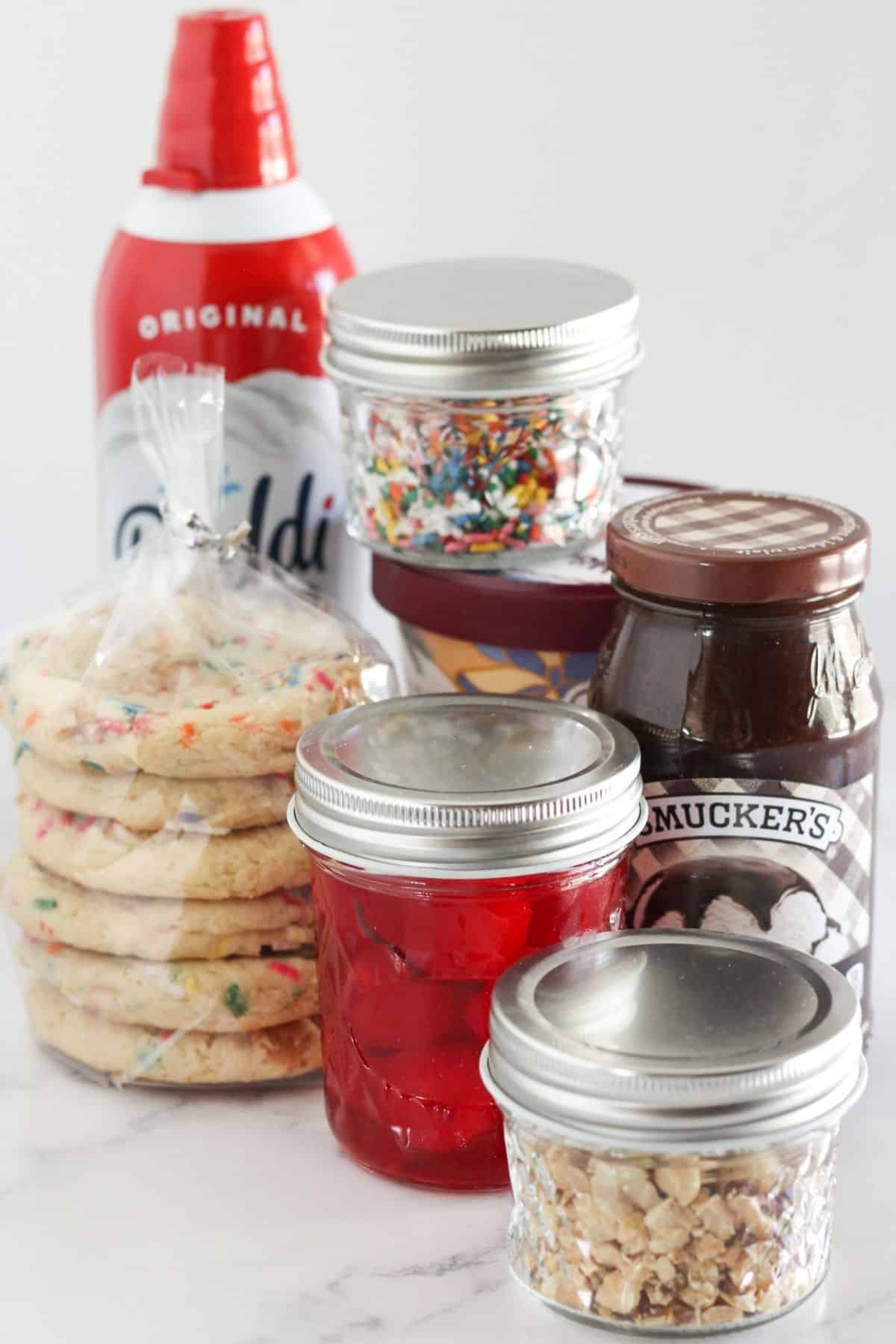 All fo the toppings for an ice cream sundae cookie bar.