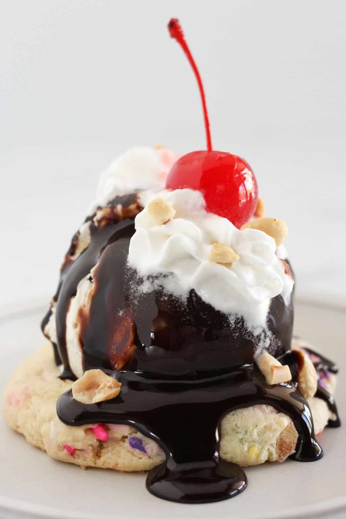 An assembled ice cream sundae cookie with toppings.