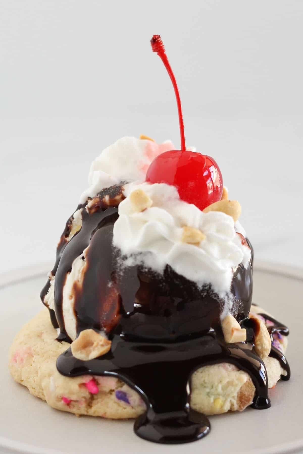 An ice cream sundae cookie topped with ice cream and toppings.