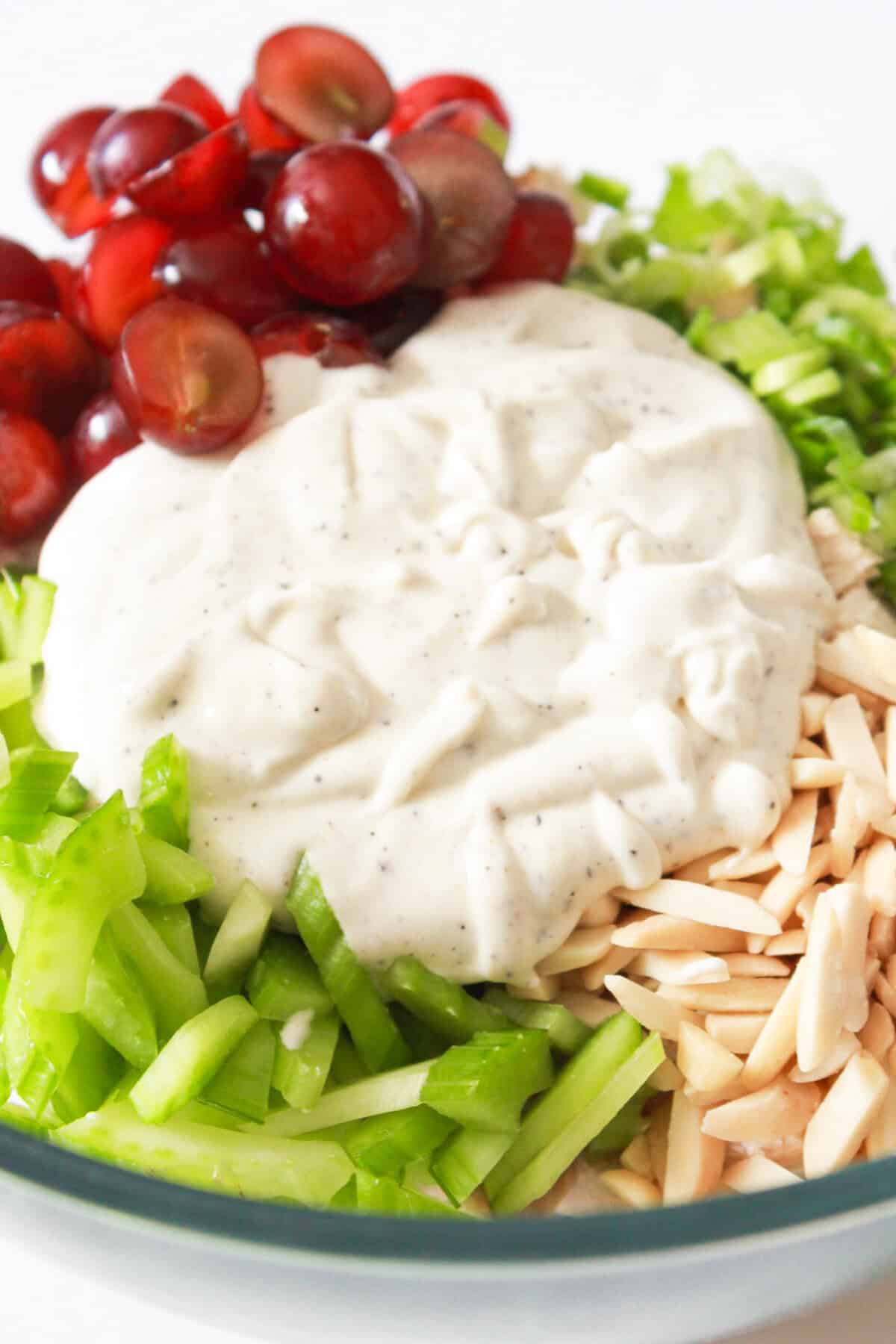 Chicken salad ingredients topped with a creamy dressing.