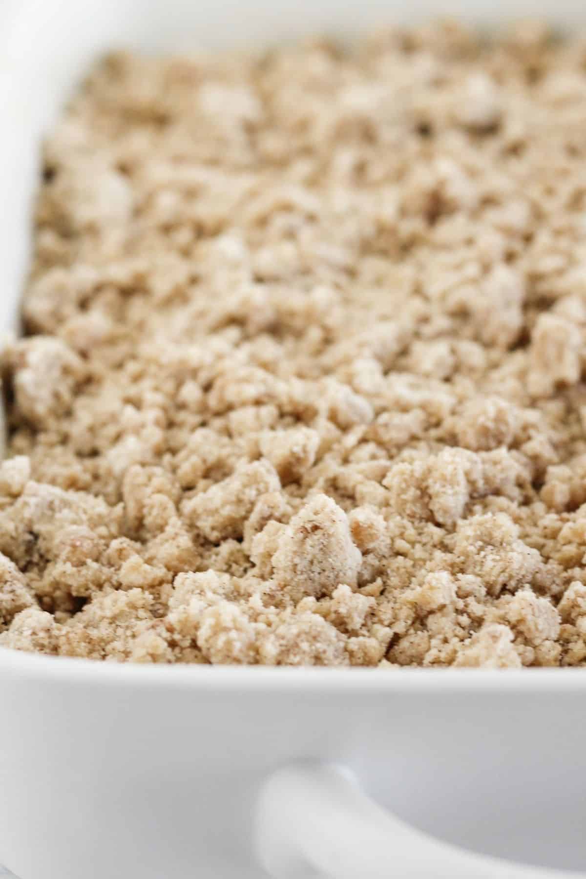 Topping zucchini cake batter with crumb topping.