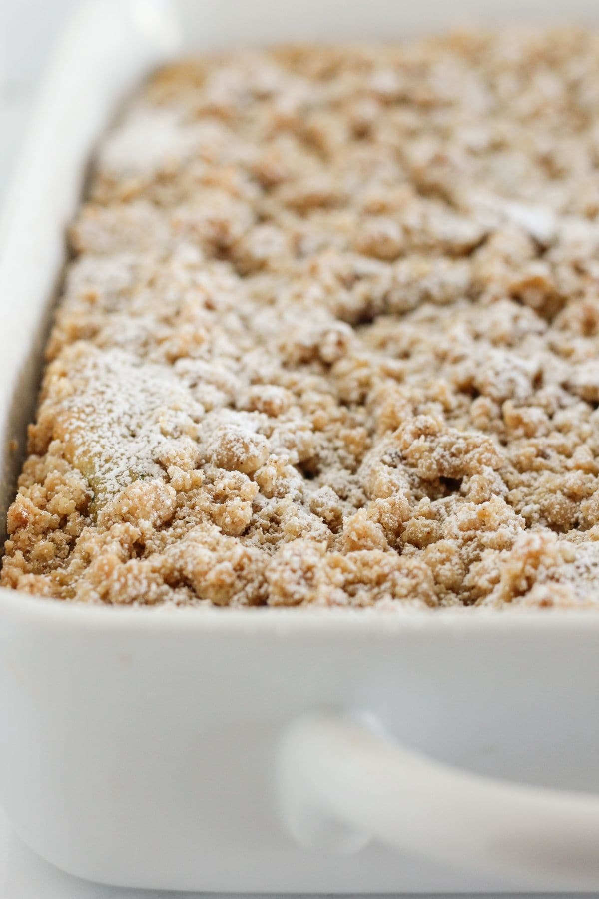 Zucchini crumb cake topped with powdered sugar.