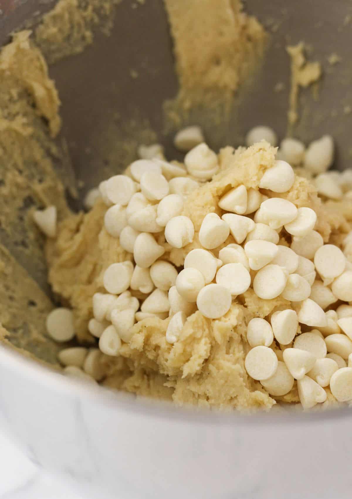 Adding white chocolate chips to the sugar cookie dough.