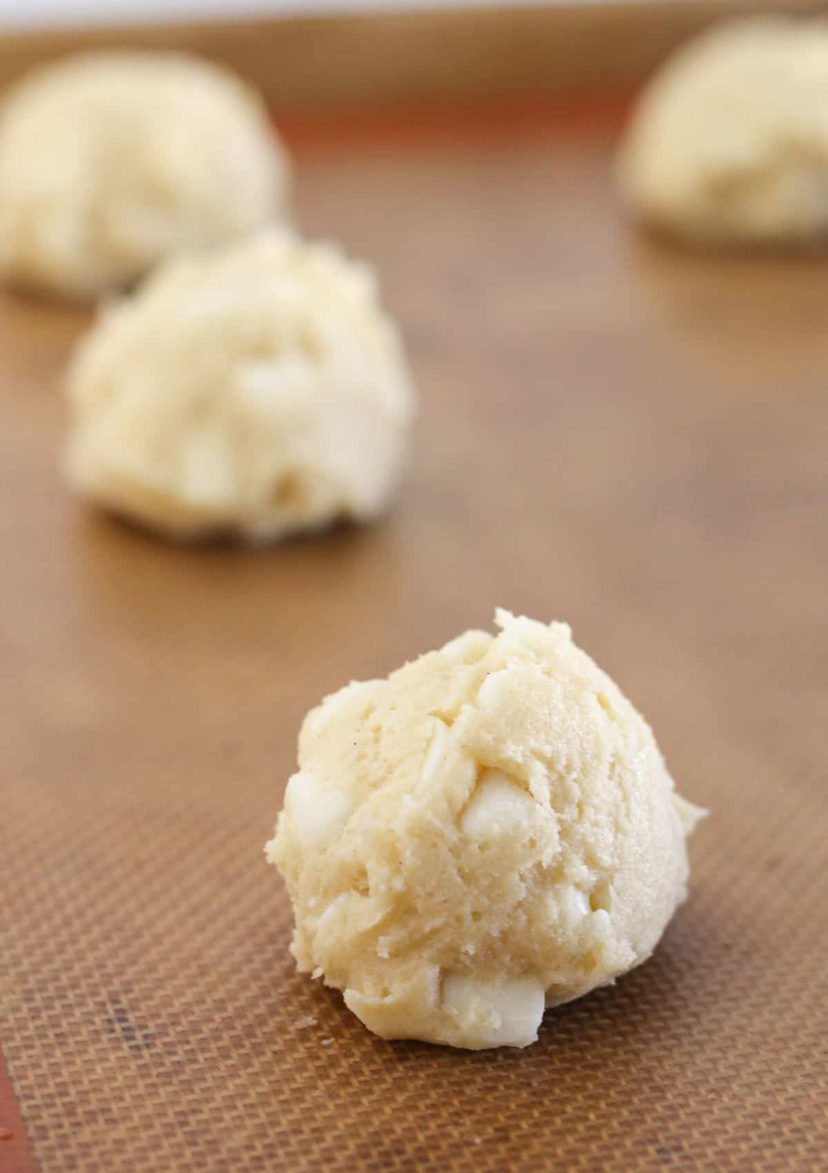 Scooping the cookie dough onto a prepared baking sheet.