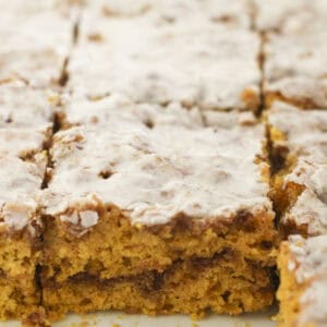 Pumpkin cinnamon roll cake cut into squares.
