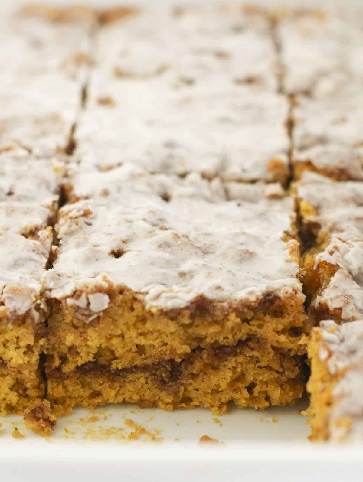 Pumpkin cinnamon roll cake cut into squares.