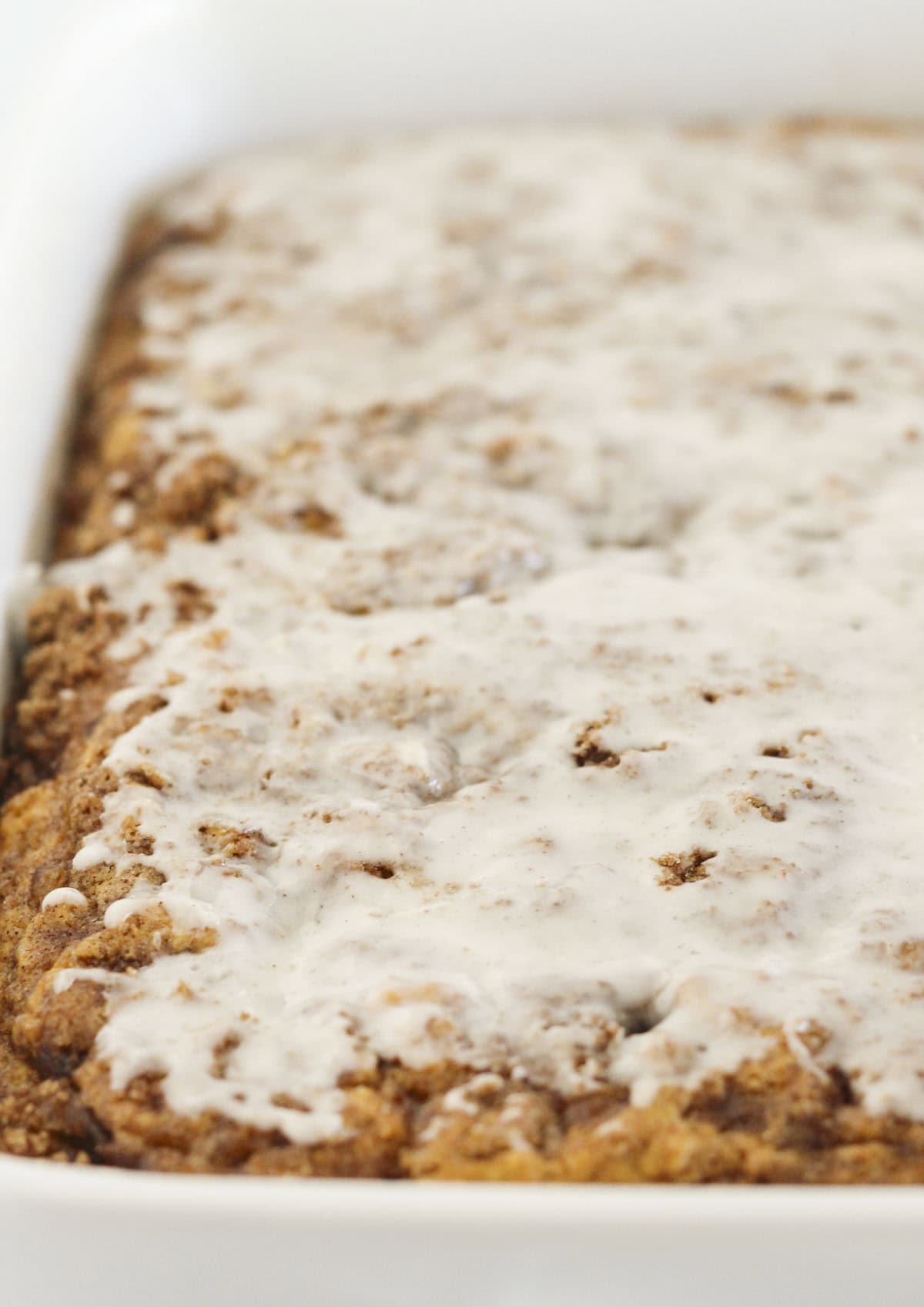Adding glaze to the top of the pumpkin cake.