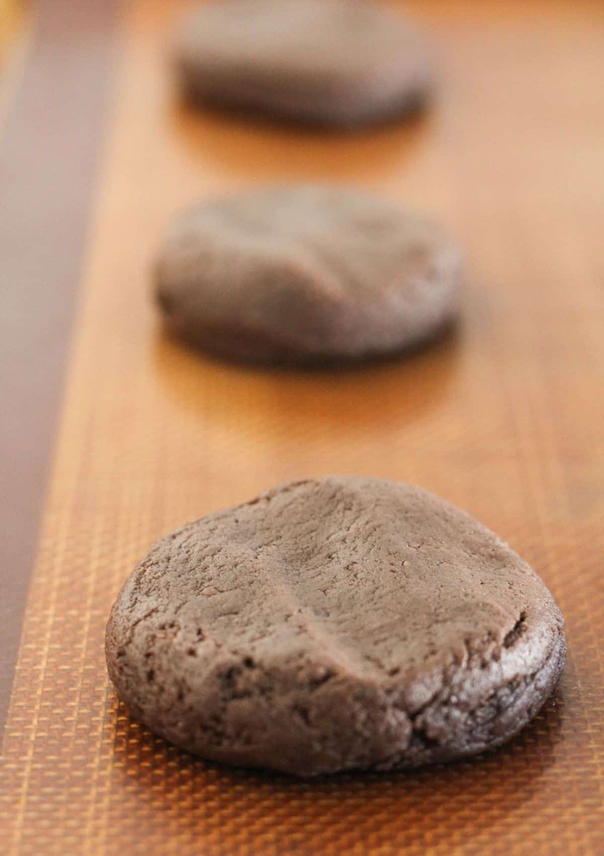 Cookie dough discs on a cookie sheet.