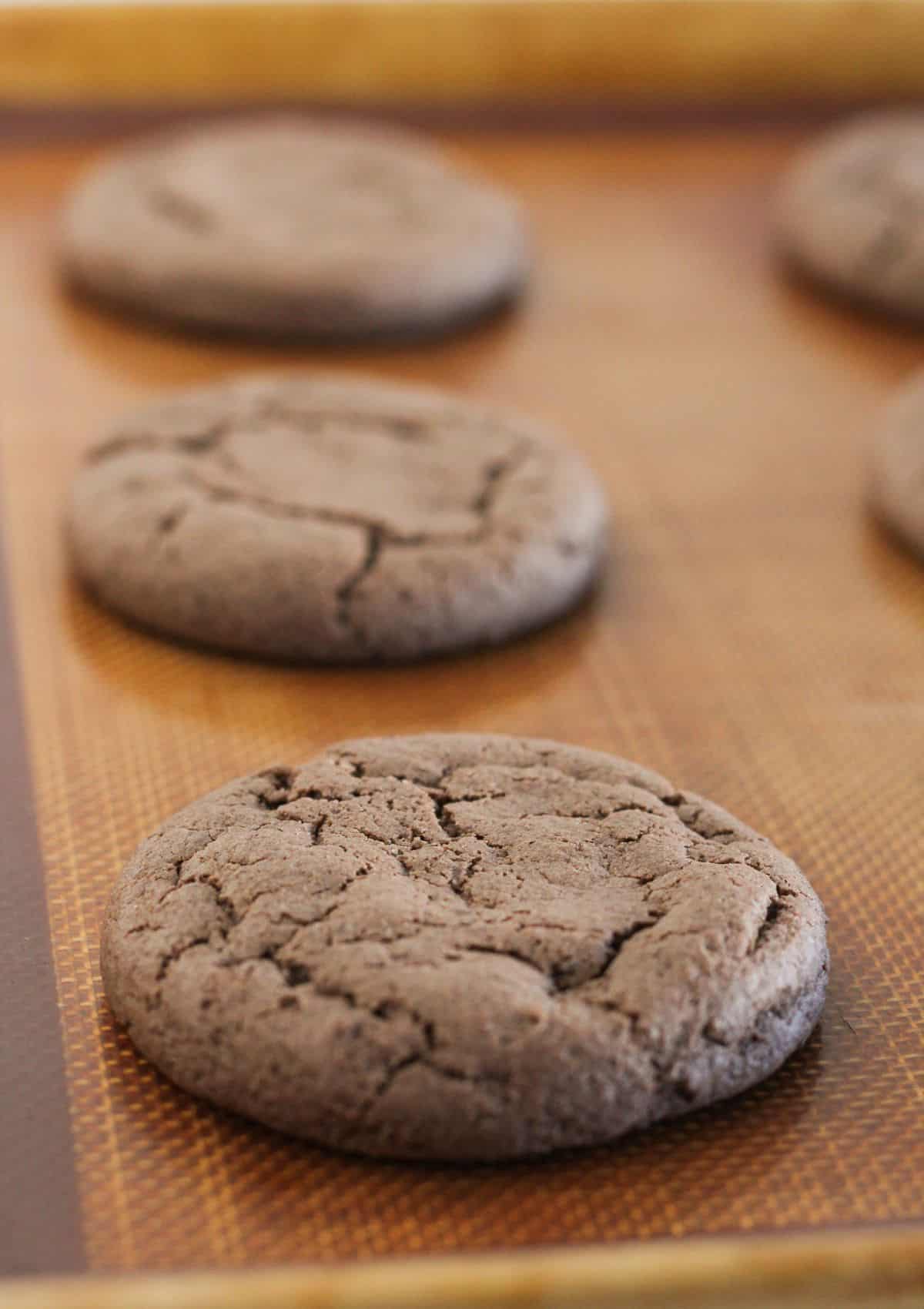 Baked chocolate cookies on a baking sheet.