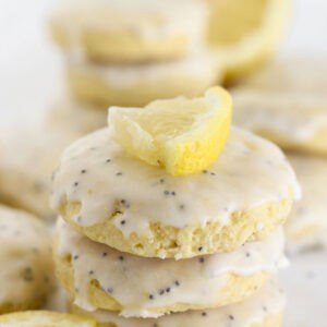 Easy to make Lemon Poppy Seed Cookies stacked on a tray with a lemon wedge.