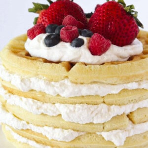 A waffle cake with homemade whipped cream and fresh berries.