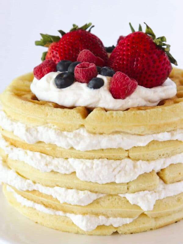A waffle cake with homemade whipped cream and fresh berries.