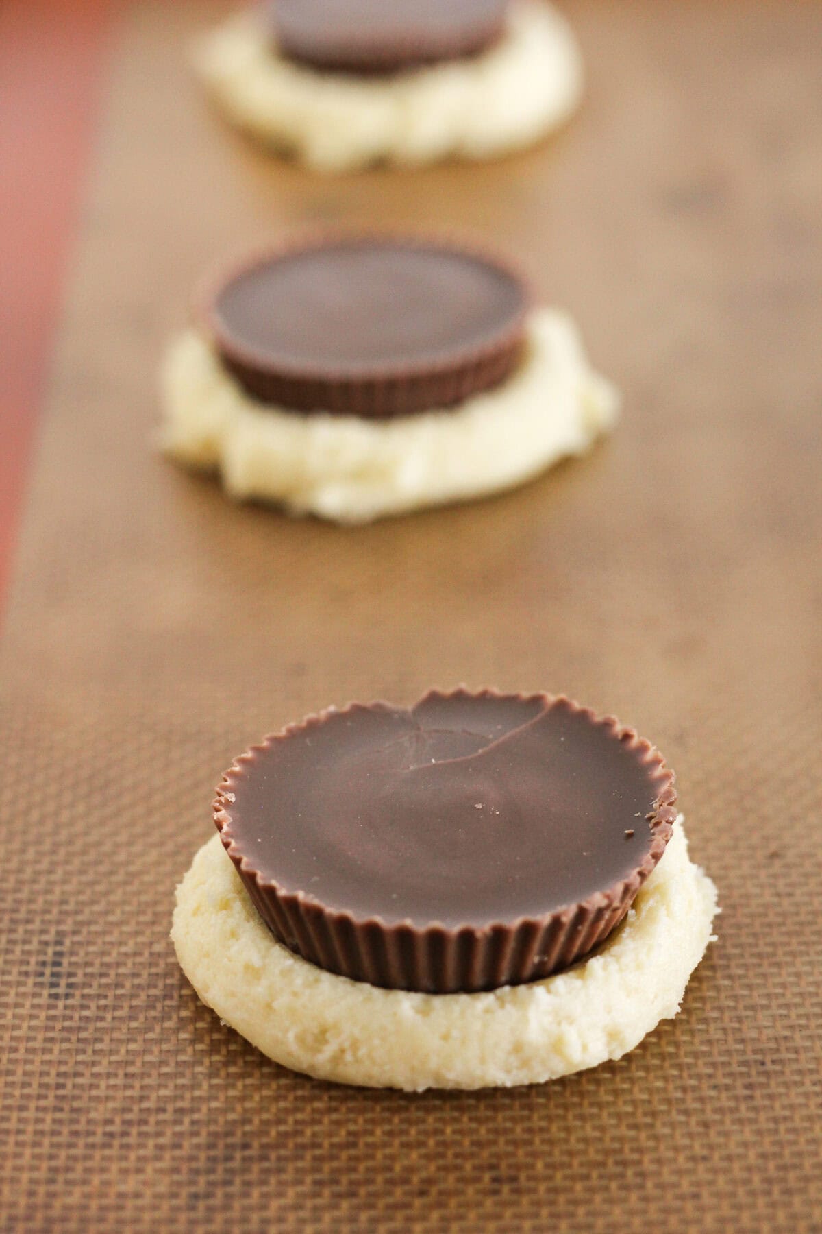 Adding a peanut butter cup to the top of cake mix cookie dough.