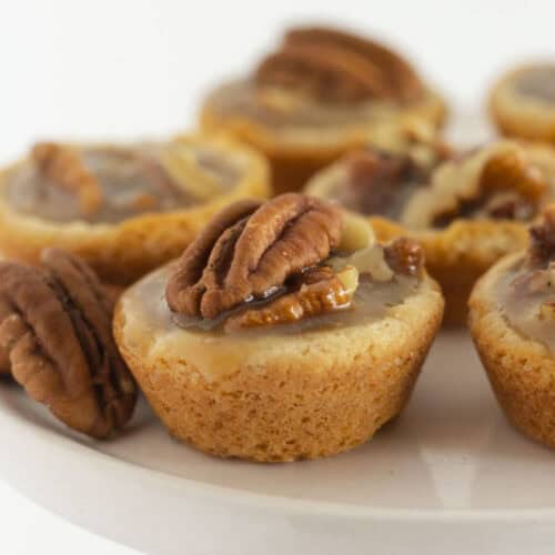 Pecan pie cookies on a white cake plate.