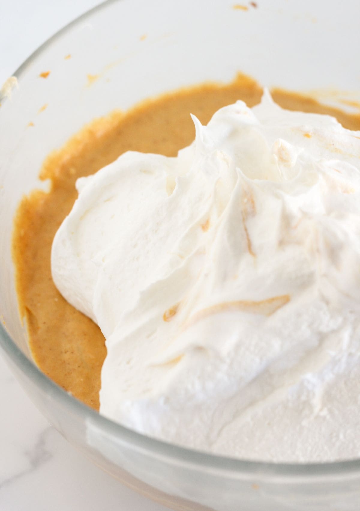 Finishing the pumpkin mousse pie filling with whipped topping.