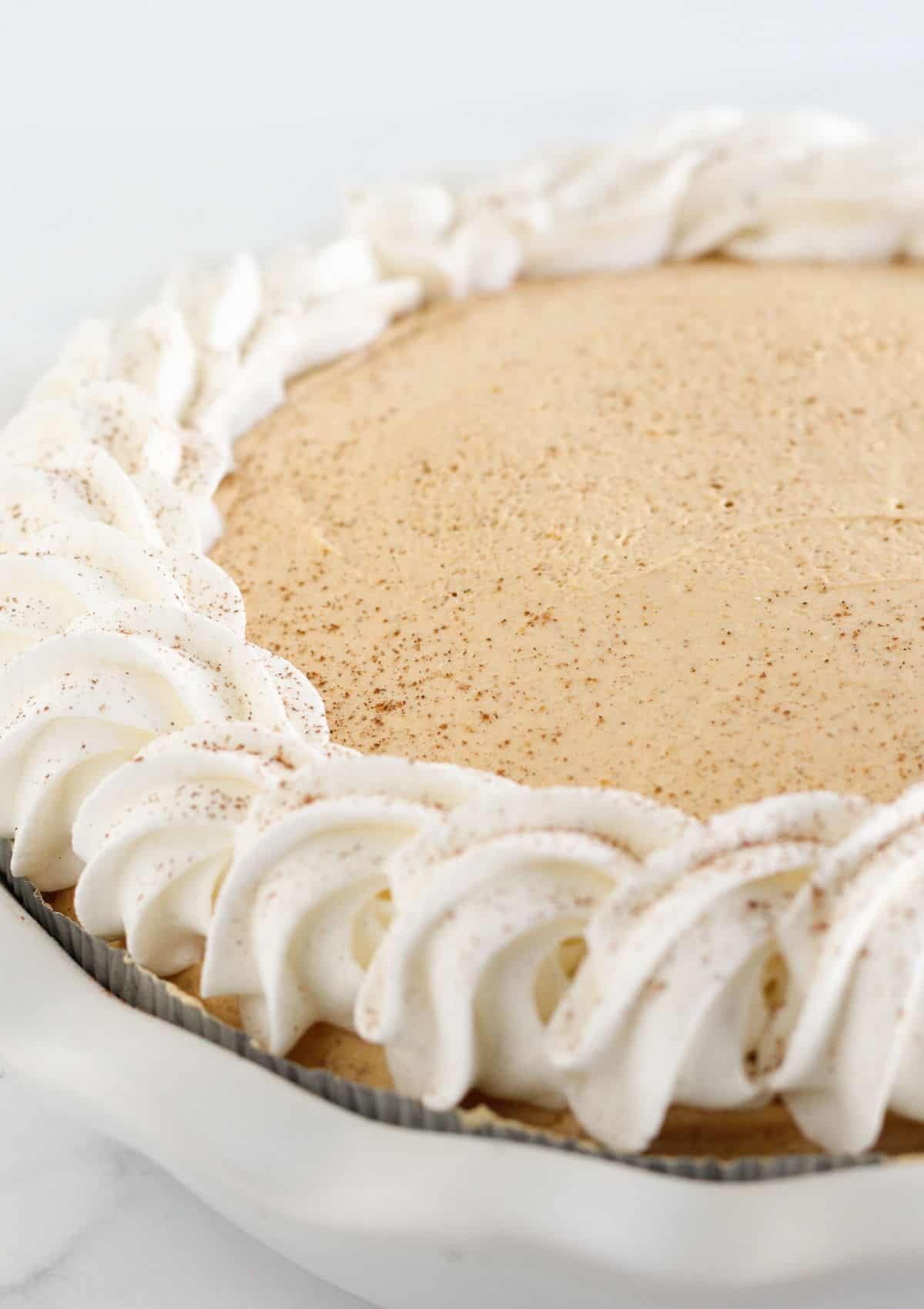 Adding whipped topping to the top of the pie after chilling.