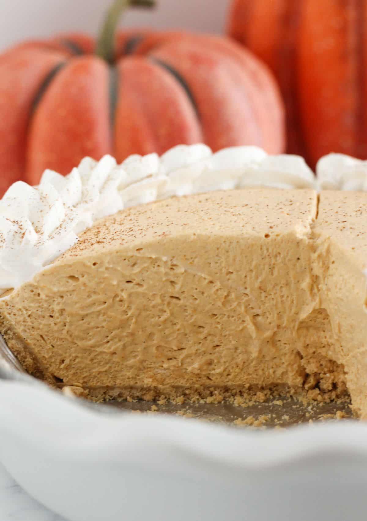 A pumpkin mousse pie with slices taken from it.