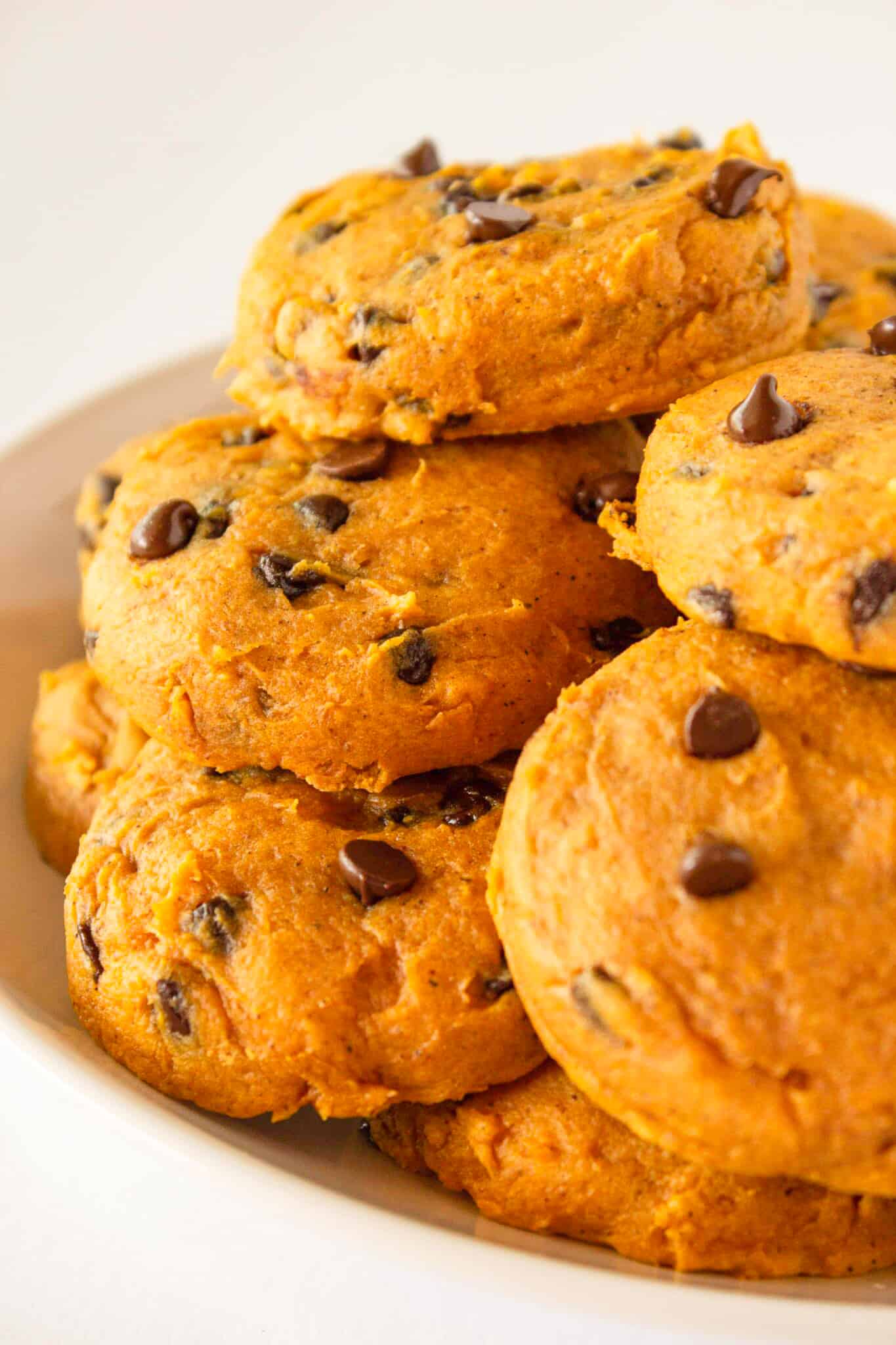A plate full of soft Pumpkin Chocolate Chip Cookies that are made with a cake mix.