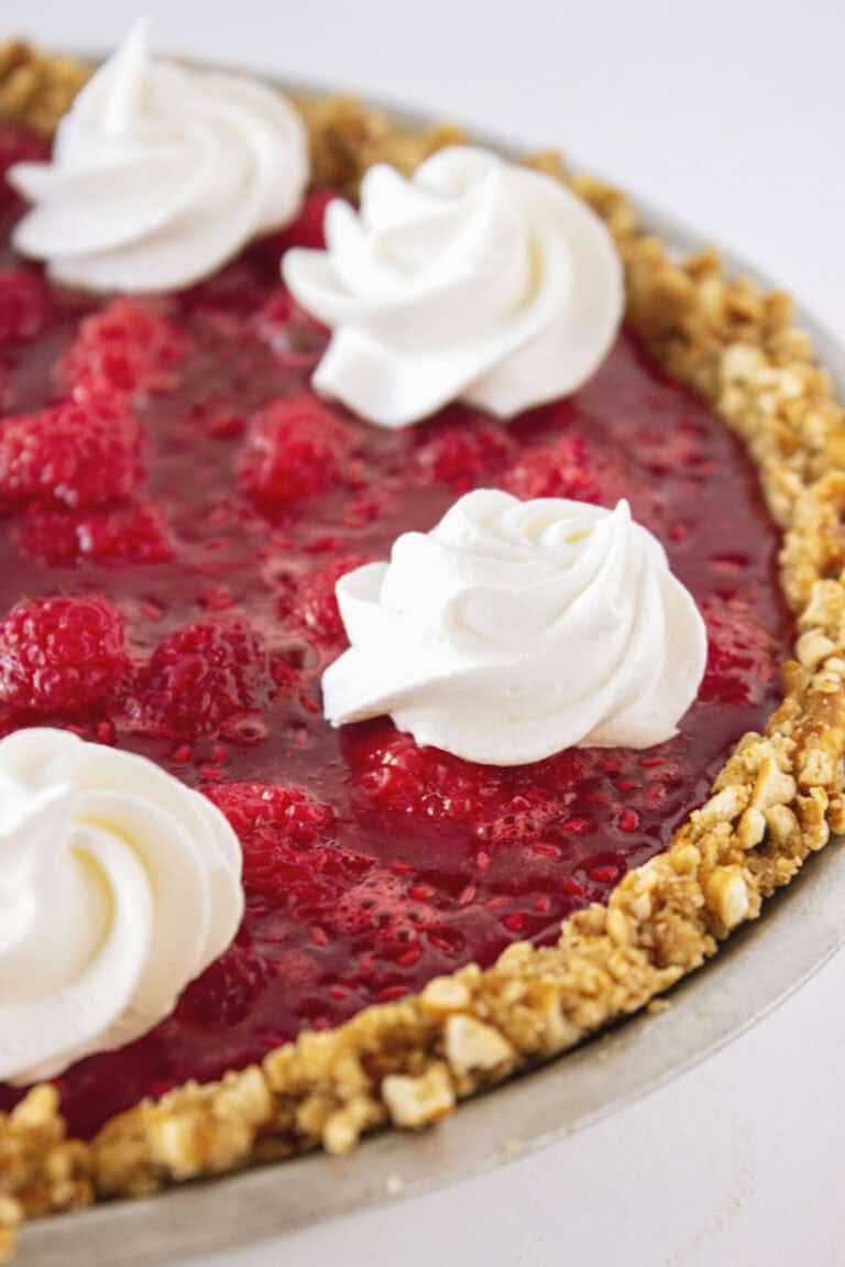 A raspberry pretzel pie with cheesecake filling and whipped cream.