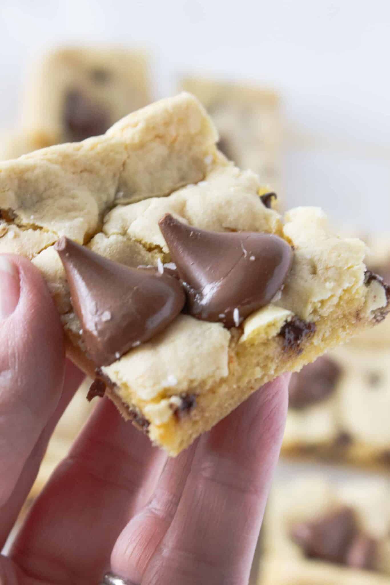Brown Butter Hersheys Kiss Cookie Bar in a hand and ready to eat.