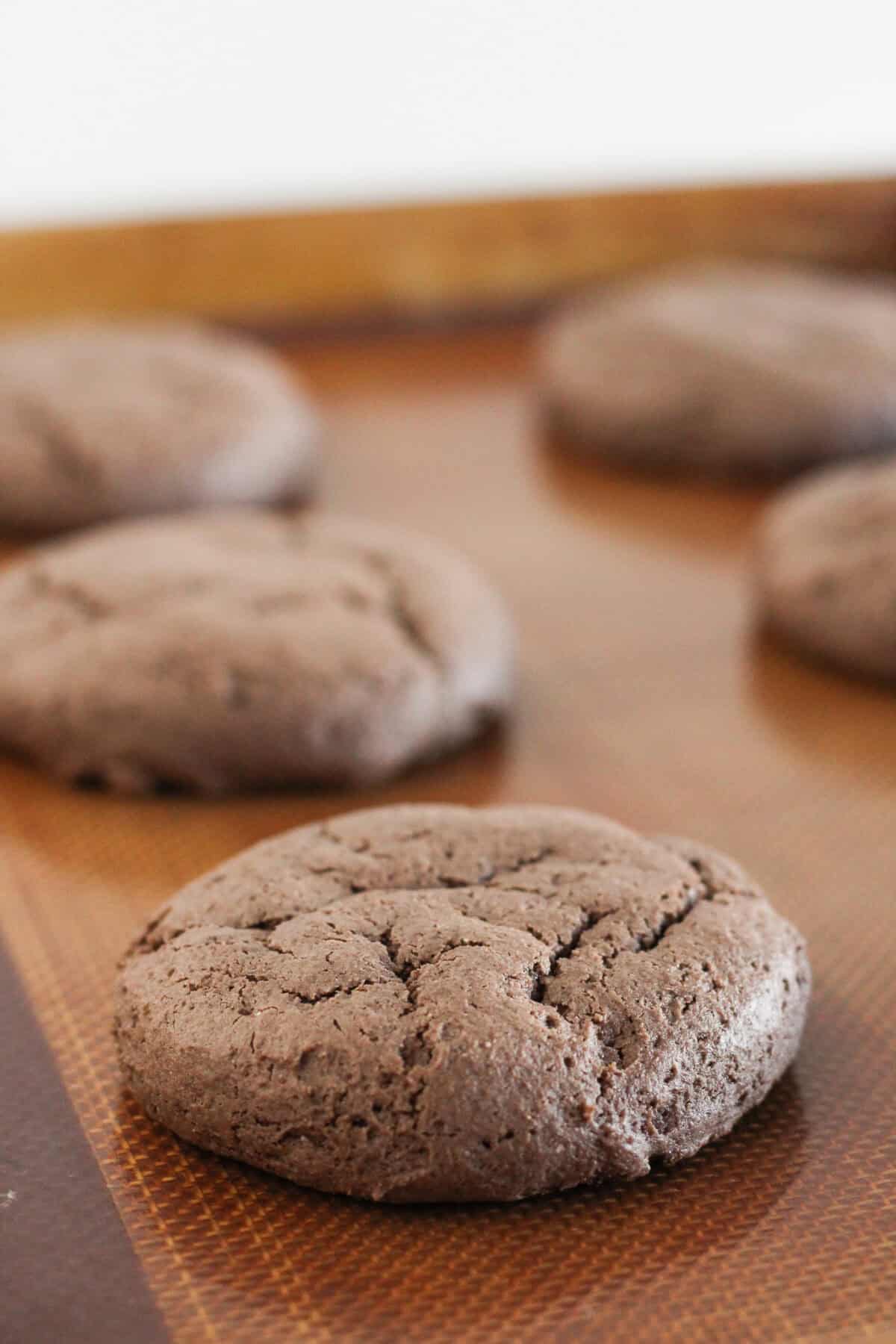 Baked chocolate cookies made with cake mix on a baking tray.