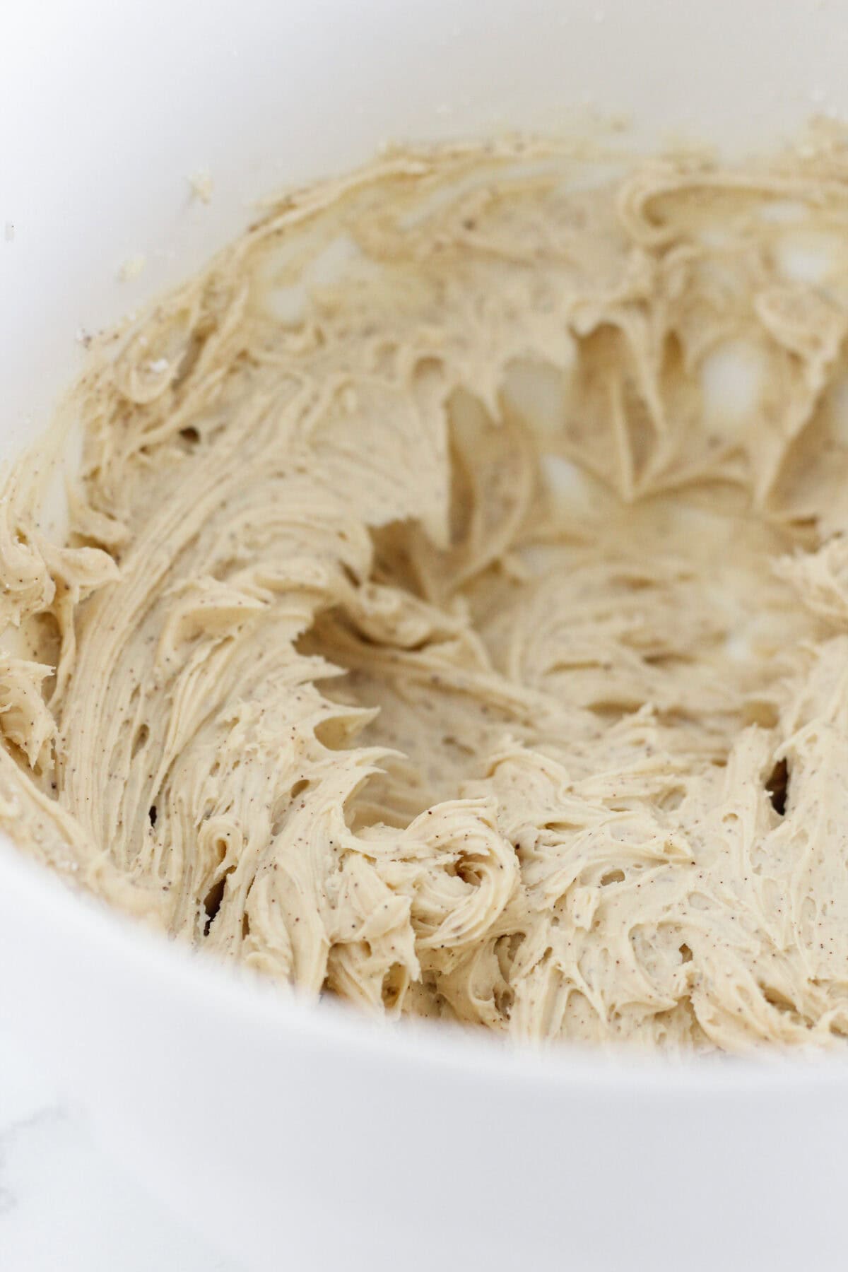 Making the espresso buttercream in a white bowl.