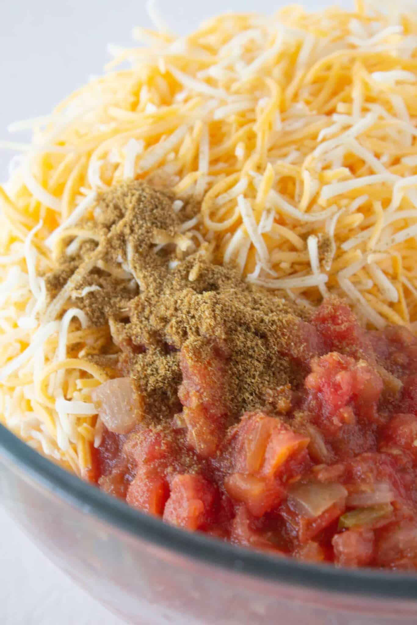 Adding cheese, salsa and spices to the chicken filling.