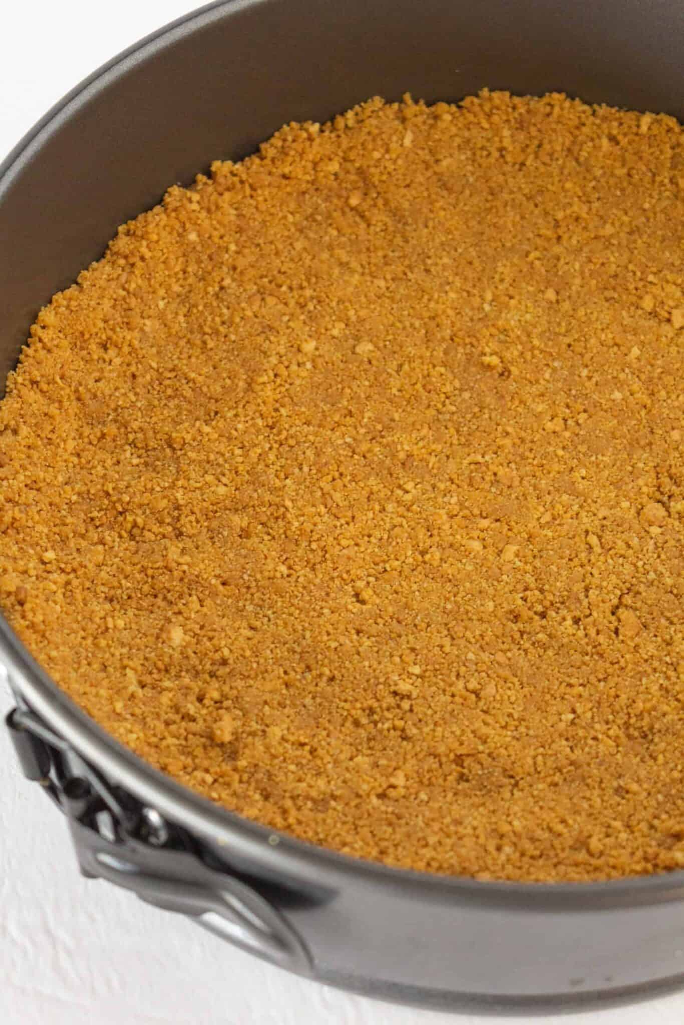 Making the graham cracker crust for the cheesecake.