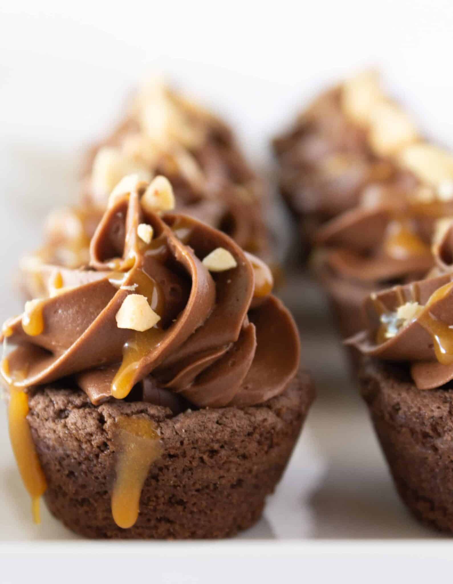 Easy Snickers Cookie Cups on a white tray with a caramel drizzle.