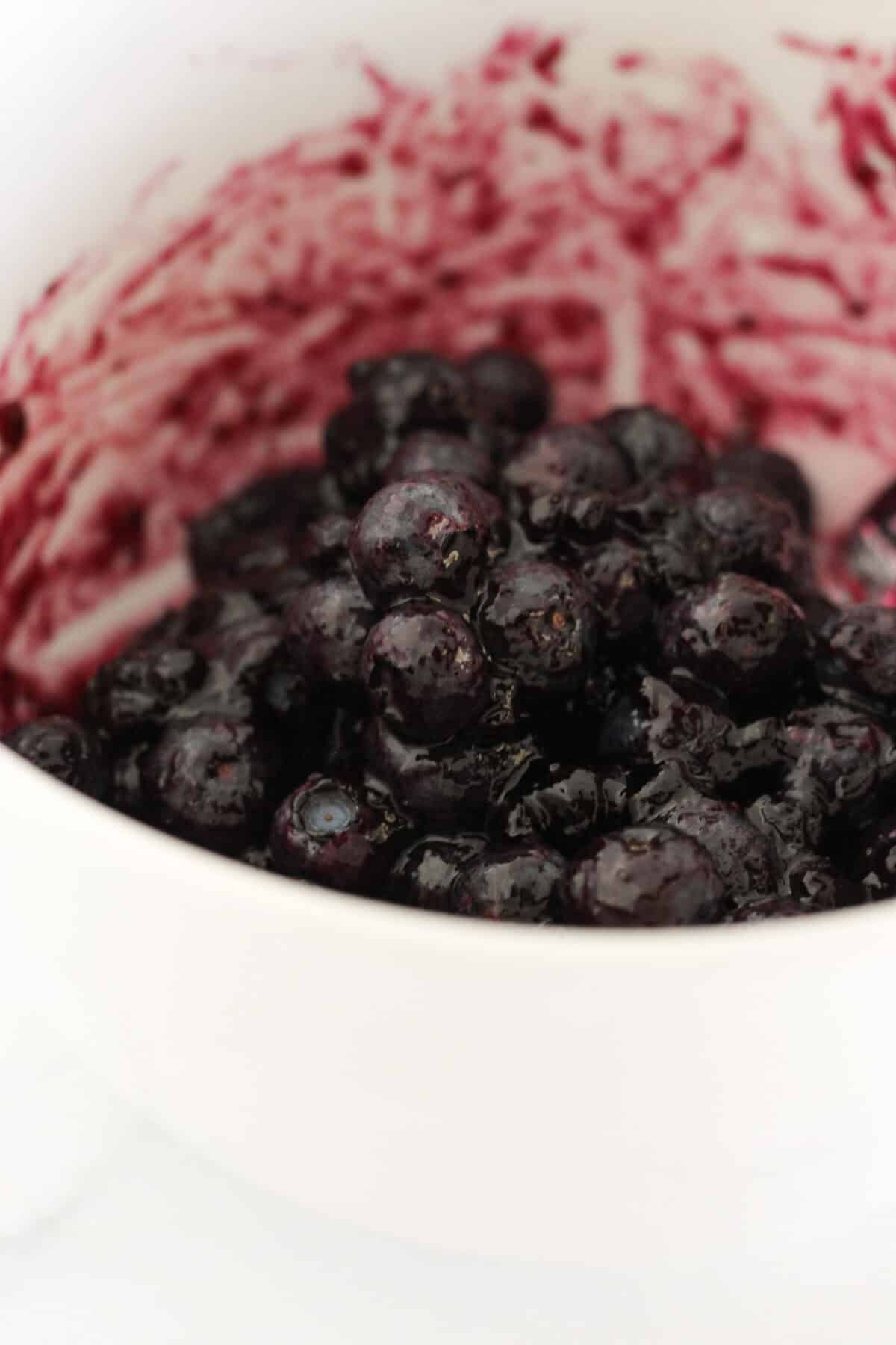 Combining fresh blueberries with blueberry jam for the topping.