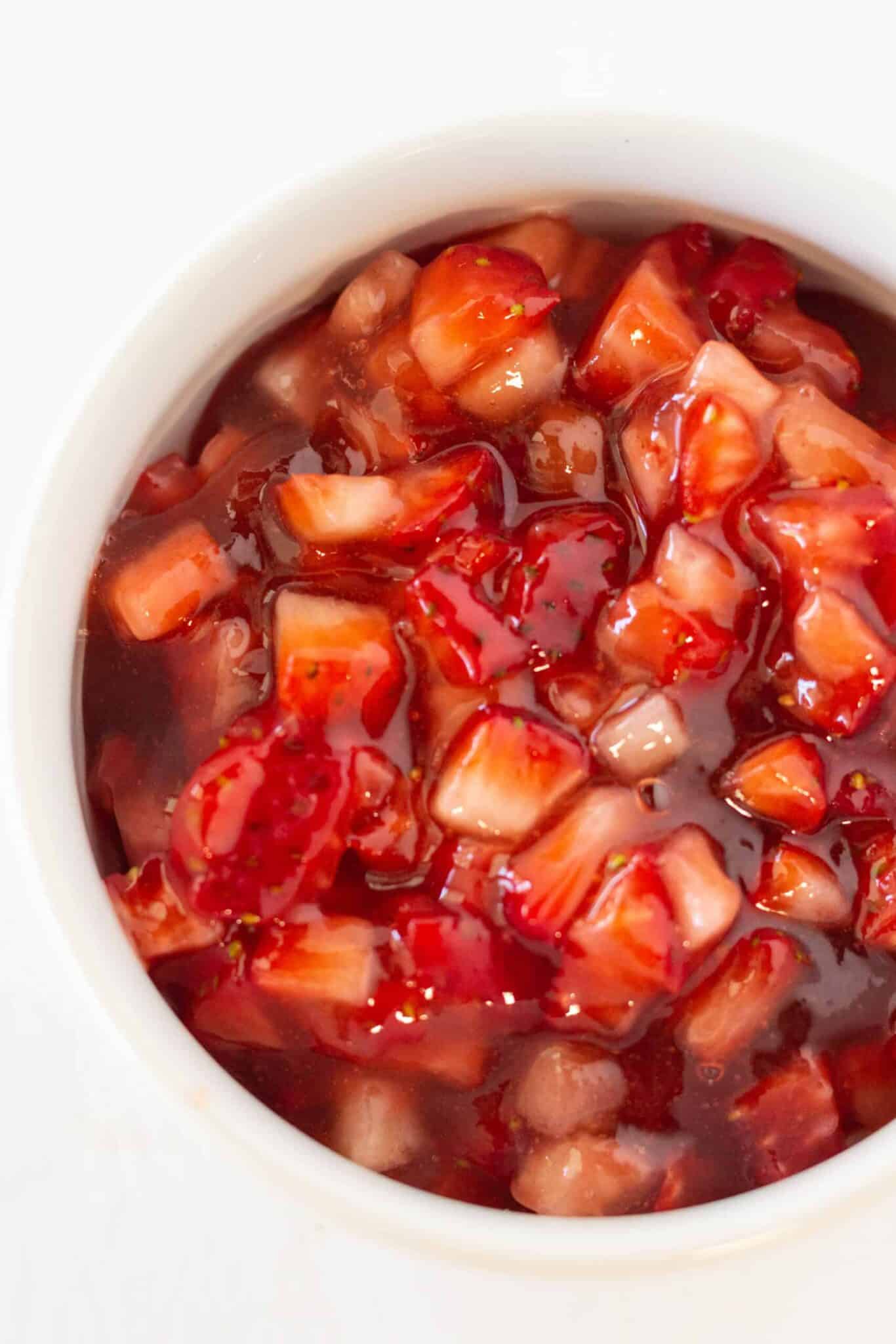 Filling the cookie cups with cream cheese filling and making the strawberry topping.