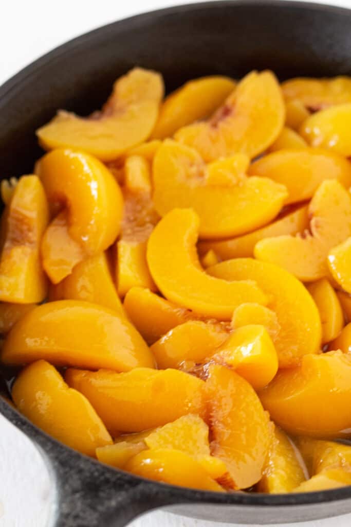 Canned peaches in a cast iron skillet .