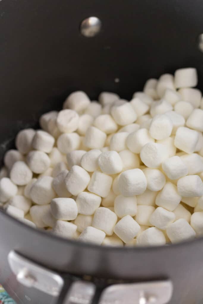 Mini marshmallows in a black saucepan with melted butter.