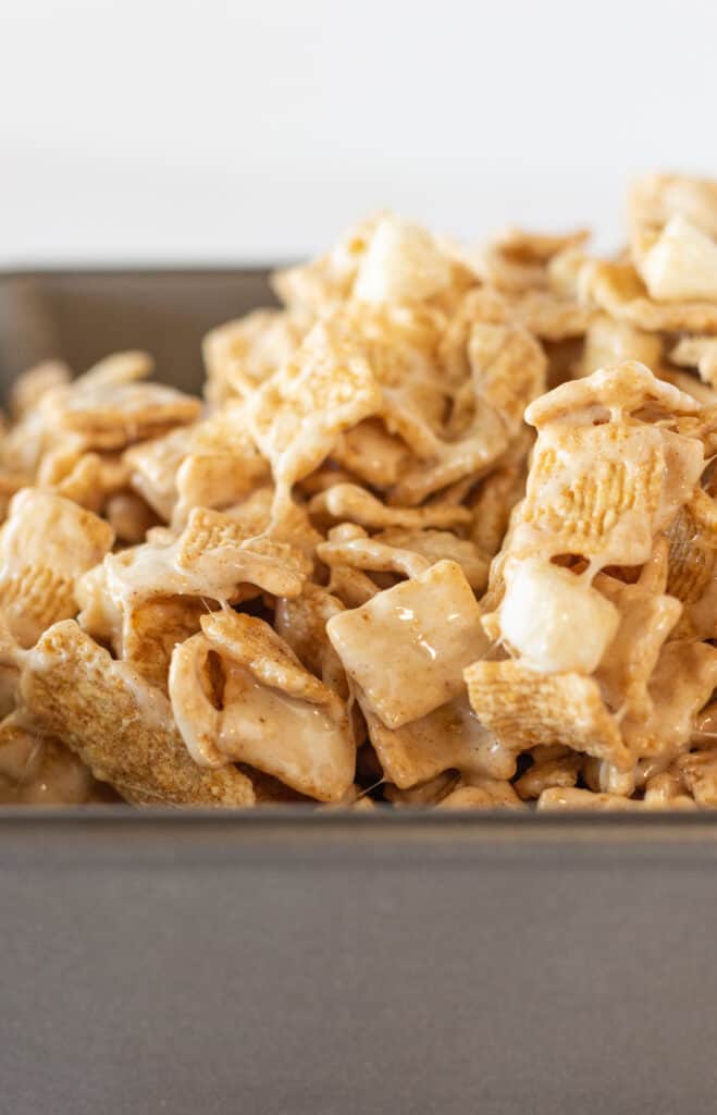 The mixture for cinnamon toast crunch squares being poured into a baking pan.