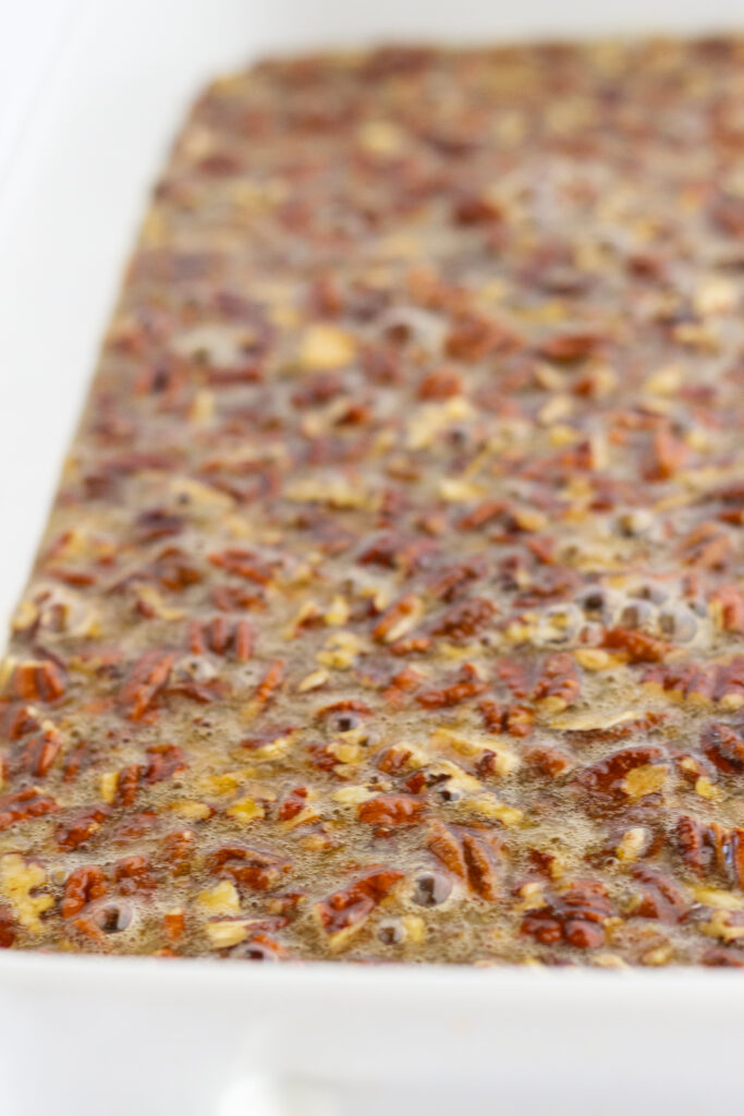 Pecan pie filling in the bottom of a baking dish.