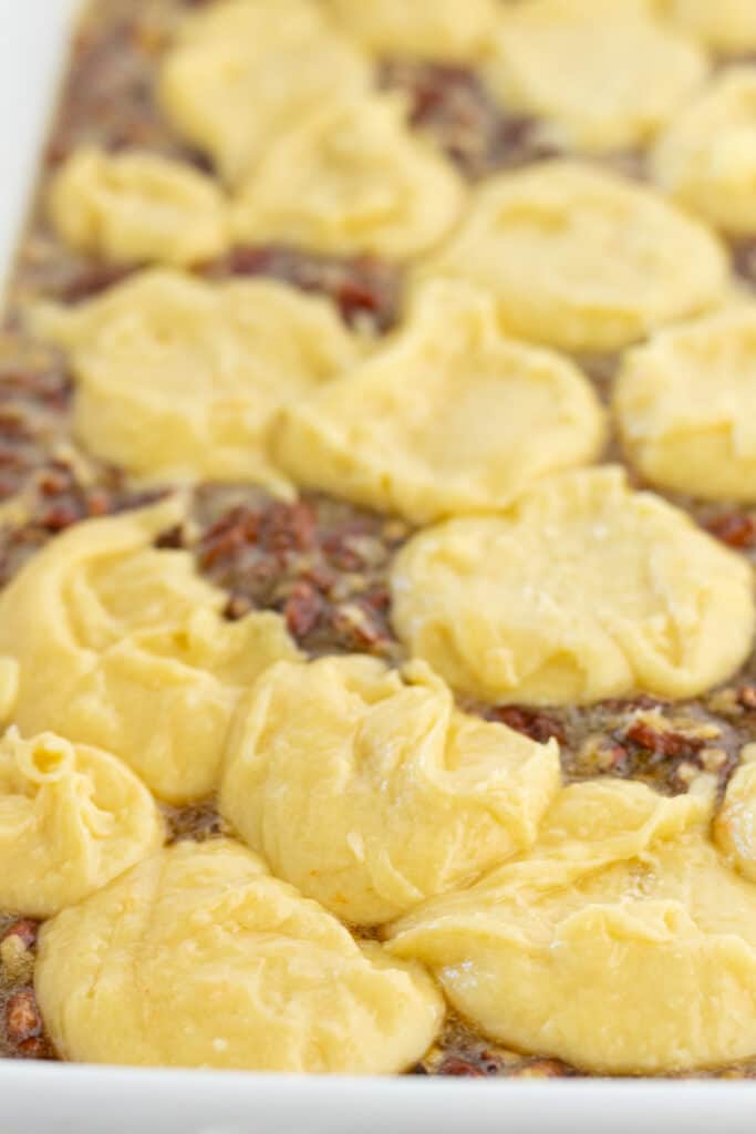 Cake mix topping on a pecan cobbler, ready to be baked.