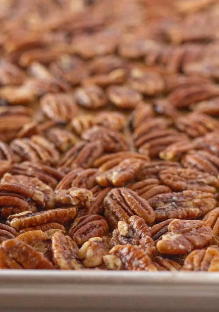 Buttered pecans on a baking sheet.