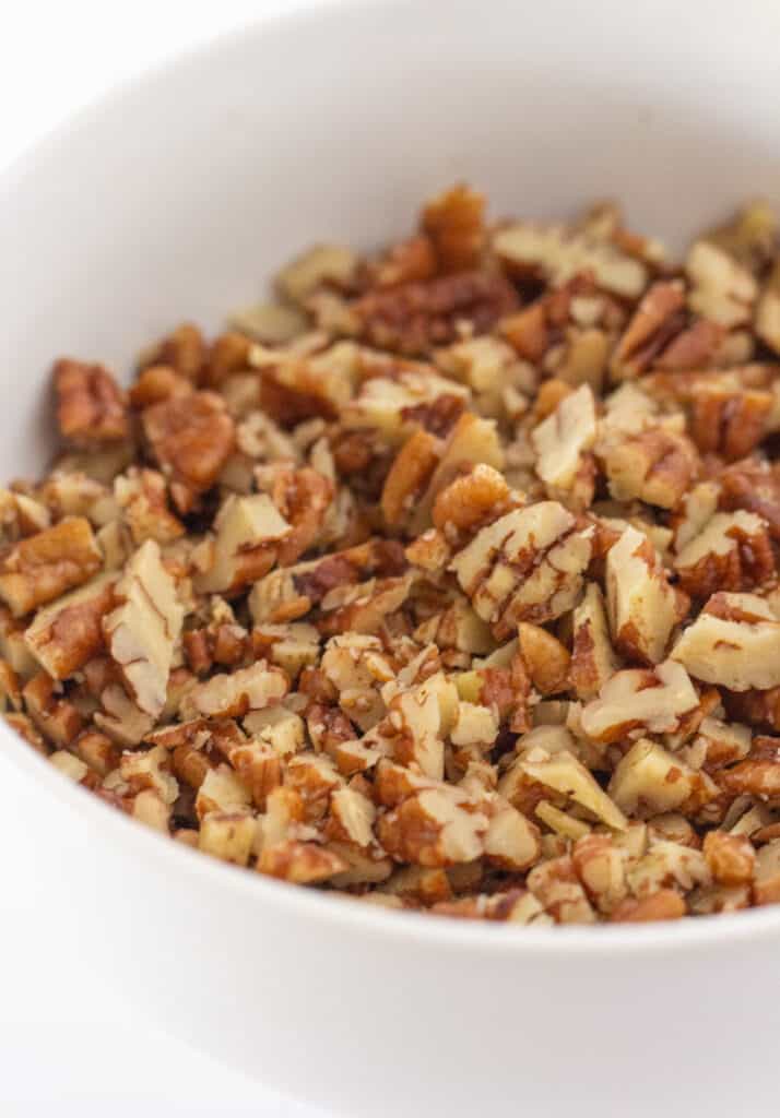 A white bowl of chopped pecans.