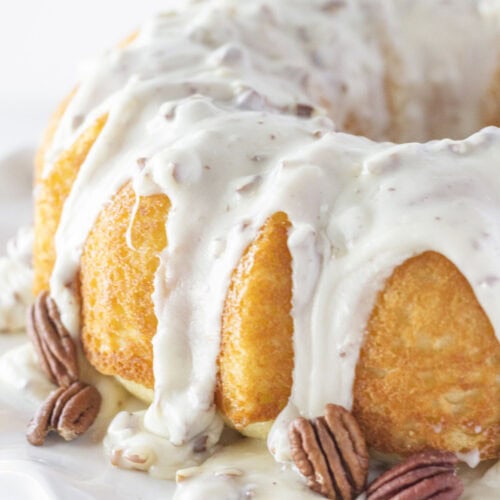A white sheet cake baked in a bundt pan with pecan frosting.